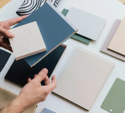 Student and multi-family FF&E material samples being examined by a designer | Turnkey FF&E & Interiors | The Living Company | Garland, Texas