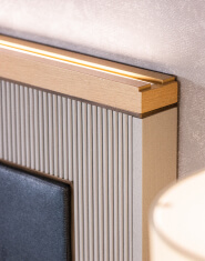 A hotel bed headboard with routing detail and integrated lighting manufactured by TLC Hospitality | The Living Company | Garland, Texas