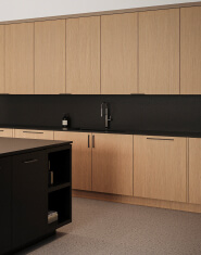 Oak kitchen cabinets and matte black pulls with black quartz counter tops | Turnkey FF&E & Interiors | The Living Company | Garland, Texas