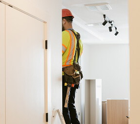Student housing kitchen cabinet installer on a ladder | Turnkey FF&E & Interiors | The Living Company | Garland, Texas